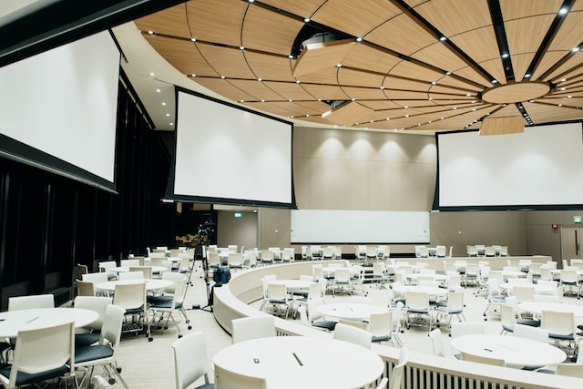 photo of empty room with projector screen - Event Conventions
